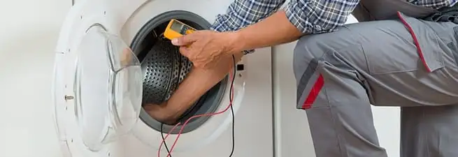 Dryer repair technician inspecting and repairing a clothes dryer in Los Angeles, CA