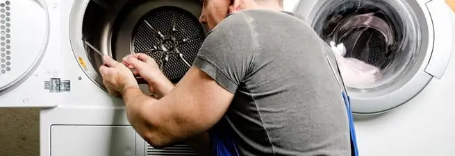 Dryer repair technician fixing a clothes dryer drum in Los Angeles, CA
