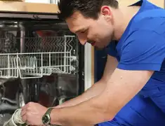 Dishwasher repair technician inspecting and servicing an open dishwasher in Los Angeles, CA