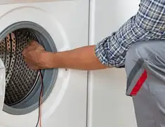Dryer repair technician diagnosing and servicing a clothes dryer in Los Angeles, CA