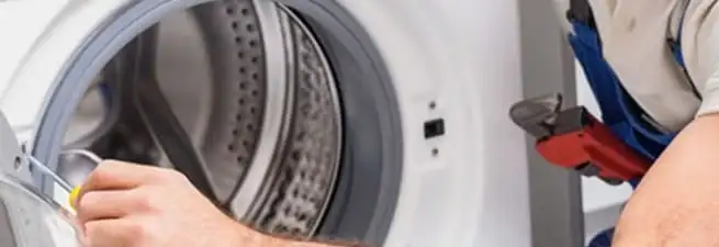 Appliance technician repairing a clothes dryer drum and internal parts in Los Angeles, CA