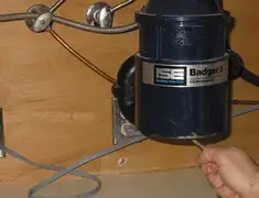 Garbage disposal repair technician tightening the mounting ring under a sink in Los Angeles, CA