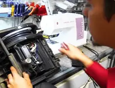 Vacuum repair technician servicing internal components on a workbench in Los Angeles, CA