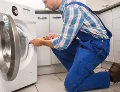 Washing machine repair technician servicing a front-load washer in Los Angeles, CA