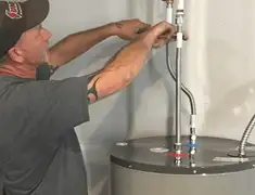 Water heater repair technician tightening supply line connections in Los Angeles, CA