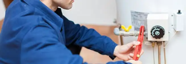 Water heater repair technician adjusting the temperature control and gas valve in Los Angeles, CA
